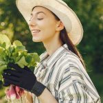 Happy woman enjoying a fresh harvest of radishes in a sunny garden.